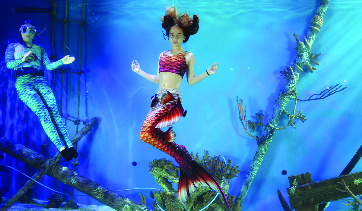 Mermaid participant posing underwater at Mertailor Aquarium