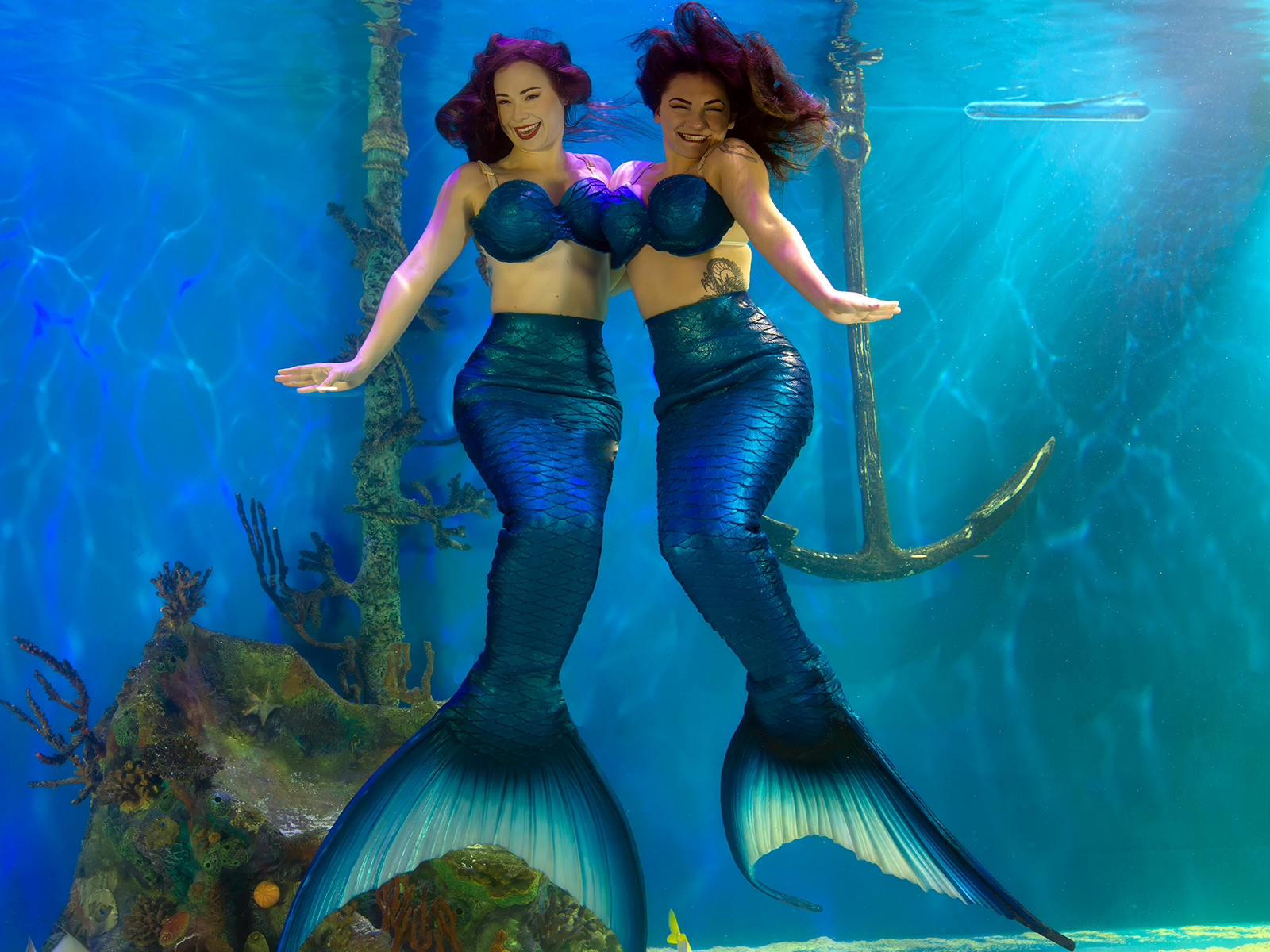 Mertailor merman and mermaid performing underwater choreography