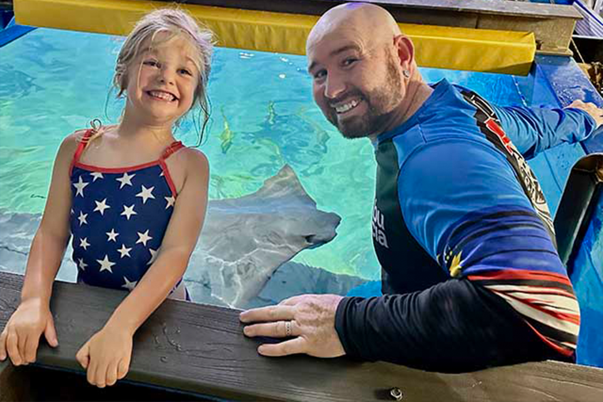Participant interacting with stingray in Mermaid Exhibit